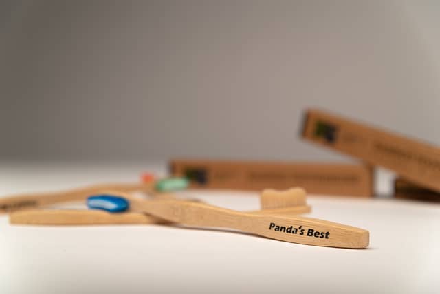 An assortment of toothbrushes lay on a white floor with the word 'Panda's Best' printed on the toothbrush in focus