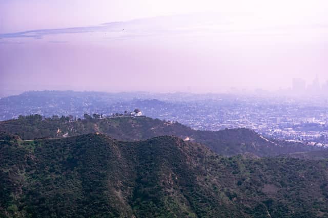 An observatory is shown deep in the foreground over cascading hills