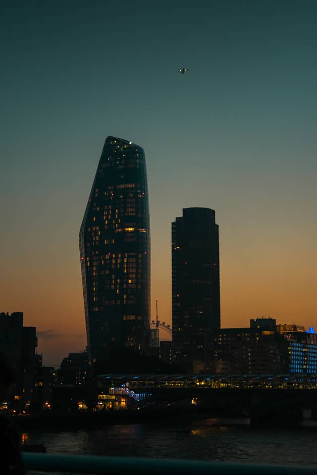 Two skyscrapers are dimmy lit behind a setting sun
